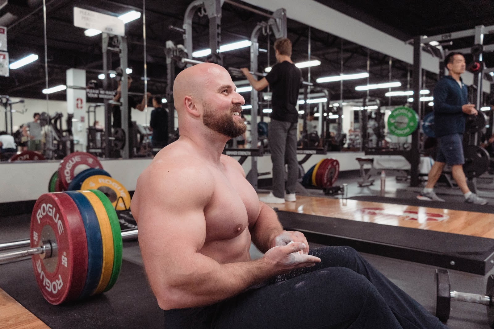 Yegor seated in a gym with chalk and weightlifting plates nearby